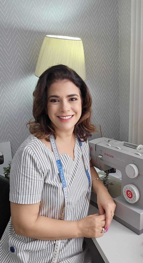 Célia Ávila na maquina de costura.
